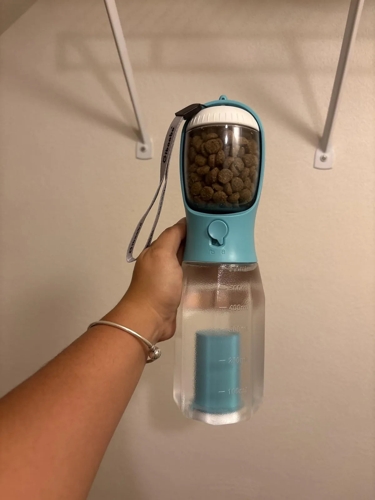 Customer photo of a blue bottle filled with dry kibble and water